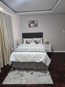 een slaapkamer met een groot bed met twee nachtkastjes bij Phozi Inn in Eshowe +11 foto's