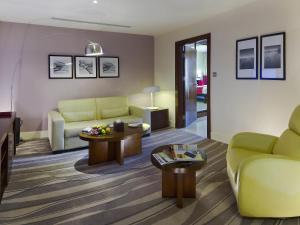 a living room with a couch and a table at Novotel Suites Riyadh Olaya in Riyadh