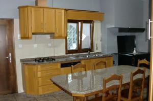a kitchen with wooden cabinets and a table with chairs at Quinta das Lindas in Mondim de Basto
