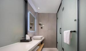 een badkamer met een wastafel en een spiegel bij Aijing International Hotel  +32 foto's