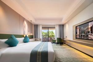 een hotelkamer met een groot bed en een groot raam bij Aijing International Hotel 