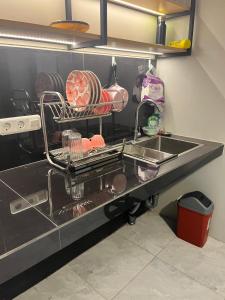 a kitchen counter with a sink with plates and pans at ABD Home Blitar syariah at Blitar City in Blitar +6 photos