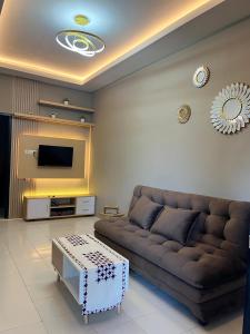a living room with a couch and a tv at ABD Home Blitar syariah at Blitar City in Blitar