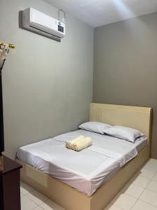 a bedroom with a bed with a towel on it at ABD Home Blitar syariah at Blitar City in Blitar