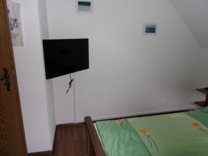 Schlafzimmer mit einem Bett und einem Flachbild-TV an der Wand in der Unterkunft Ferienwohnung Hartmann in Frankenau