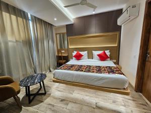 a bedroom with a large bed with red pillows at Travellers Hotel in New Delhi