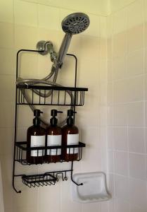 a bathroom rack with four bottles of soap at Master Suite with Private Bath 15 min drive to beach in Hilo +27 photos