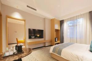 een hotelkamer met een bed en een televisie bij Aijing International Hotel 