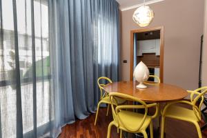 a dining room with a table and yellow chairs at Apulia Re' Aparthotel & Suites in Bari