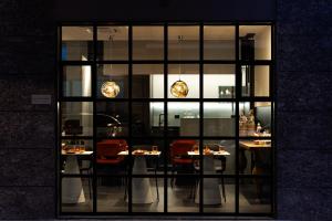 a restaurant with tables and chairs in a window at Apulia Re' Aparthotel & Suites in Bari +108 photos
