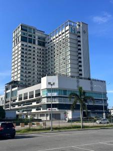 a large building with a palm tree in front of it at Nasai Retreat Studio in H Elite Design Building in Kota Bharu