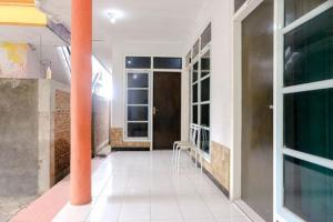 a hallway with a door and a chair in a building at FIVE HOTEL Sarangan in Sarangan