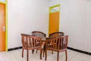 a wooden table with four chairs and a mirror at FIVE HOTEL Sarangan in Sarangan