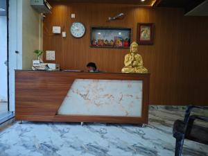 a desk with a statue in a room with a clock at Hotel aditya palace in Padrauna