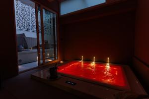 a red bath tub with candles in a room with a window at Apulia Re' Aparthotel & Suites in Bari