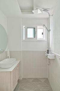 a white bathroom with a sink and a shower at 레이니데이 in Namŭm-ni