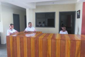 吉佐Zaru Hotel的三个男人坐在桌旁用手机聊天