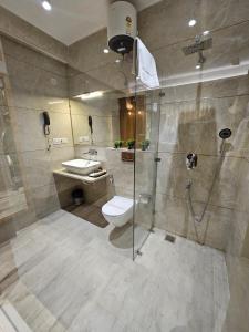 a bathroom with a shower and a toilet and a sink at Travellers Hotel in New Delhi