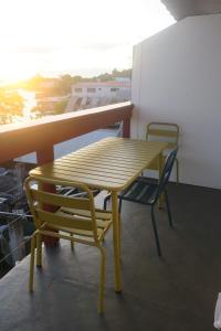 吉佐Zaru Hotel的阳台上的木桌和椅子，欣赏日落