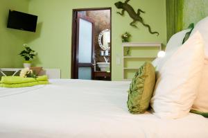 a bedroom with a white bed with a lizard on the wall at a Vue Guesthouse in Somerset West