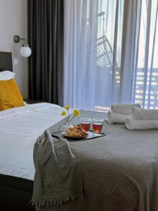 een dienblad met eten en twee glazen op een bed bij Bansko St Ivan Rilski Residences in Bansko