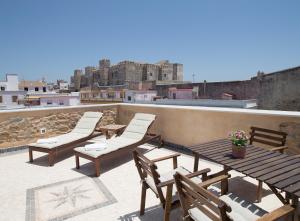 eine Terrasse mit Stühlen und einem Tisch auf dem Dach in der Unterkunft Puerta la Mar in Tarifa