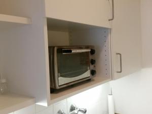 a microwave in a cabinet in a kitchen at MyCrib I Free Parking I Self Check-in in Graz
