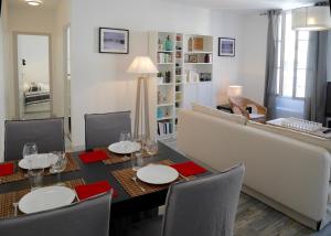 uma sala de jantar com uma mesa e um sofá em Les Appartements du Palais em Bergerac