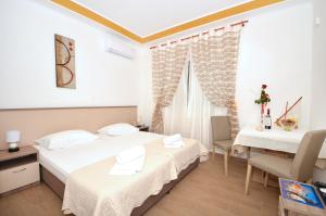 ein Hotelzimmer mit 2 Betten und einem Esstisch in der Unterkunft Guest House Mia in Split