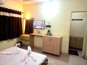 a room with a bed and a sink and a mirror at Challa Residency in Rājahmundry +4 photos