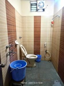 a bathroom with a toilet and a bucket in it at Challa Residency in Rājahmundry