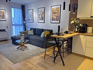 een woonkamer met een blauwe bank en een tafel bij Bansko St Ivan Rilski Residences in Bansko +34 foto's