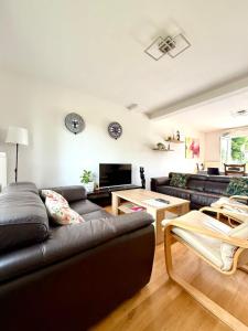 una sala de estar con un sofá y una mesa en Holiday House -10 min Clervaux Castle - near forest and shopping - Luxembourg, en Marnach