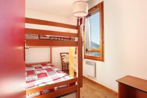 サン・フランソワ・ロンシャンにあるRésidence Odalys Belle Vueのベッドルーム(二段ベッド1組、窓付)