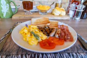 a plate of breakfast food with eggs bacon and toast at Staymore in Stellenbosch