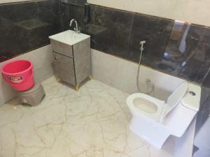 a bathroom with a toilet and a trash can at Ganga Nature Nest in Hawālbāgh +51 photos