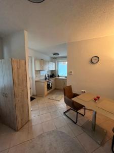 a living room with a table and a kitchen at Apartmenthaus Eldena Am Teich in Greifswald