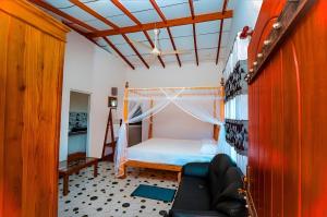 a bedroom with a bed with a mosquito net at Happy Corner Ahangama in Midigama West