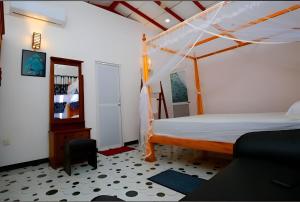a bedroom with a bed with a wooden canopy at Happy Corner Ahangama in Midigama West