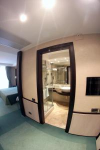 カザルヌオーヴォ・ディ・ナーポリにあるHotel San Mauroの鏡付きの部屋、バスルーム(バスタブ付)