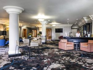 a hotel lobby with a bar and chairs at Mercure Dartford Brands Hatch Hotel & Spa in Dartford