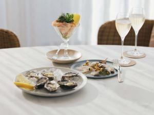 a table with plates of food and glasses of wine at Elysium Noosa Resort - MGallery Collection in Noosa Heads