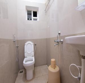 ein Badezimmer mit Toilette und Waschbecken in der Unterkunft Pondicherry Comfort Rooms in Puducherry