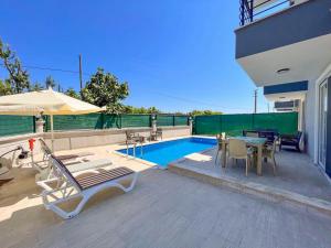 un patio con tavolo e sedie e una piscina di Villa Maya a Çayılı