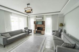 un soggiorno con due divani e una televisione di Villa Maya a Çayılı