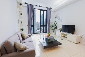 a living room with a couch and a tv at SS KL Sentral by NomadNest in Kuala Lumpur