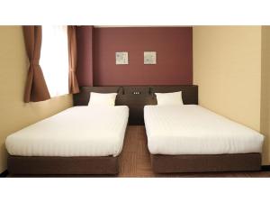 2 posti letto in una piccola stanza con lenzuola bianche di Smile Hotel Otsu Seta - Vacation STAY 00132v a Zeze-Awazumachi Altre 23 foto