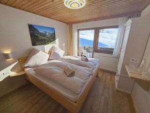 una camera da letto con due letti e una grande finestra di Pension Panorama Warth a Lechleiten