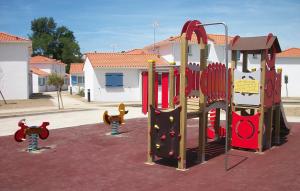 a playground with a play equipment in a parking lot at Résidence Odalys Le Domaine de l'Océan in Saint-Brévin-lʼOcéan