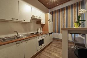 una cocina con armarios blancos y fregadero en Hofmanns B&B en Loosdorf